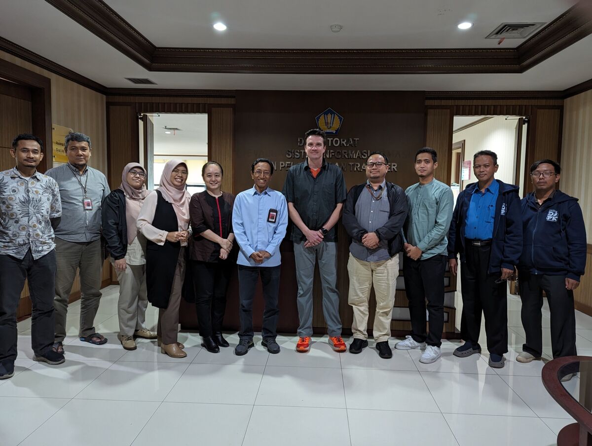 Bartosz Solowiej standing with members of an Indonesian Ministry of Finance team in front of the directorate&rsquo;s sign.