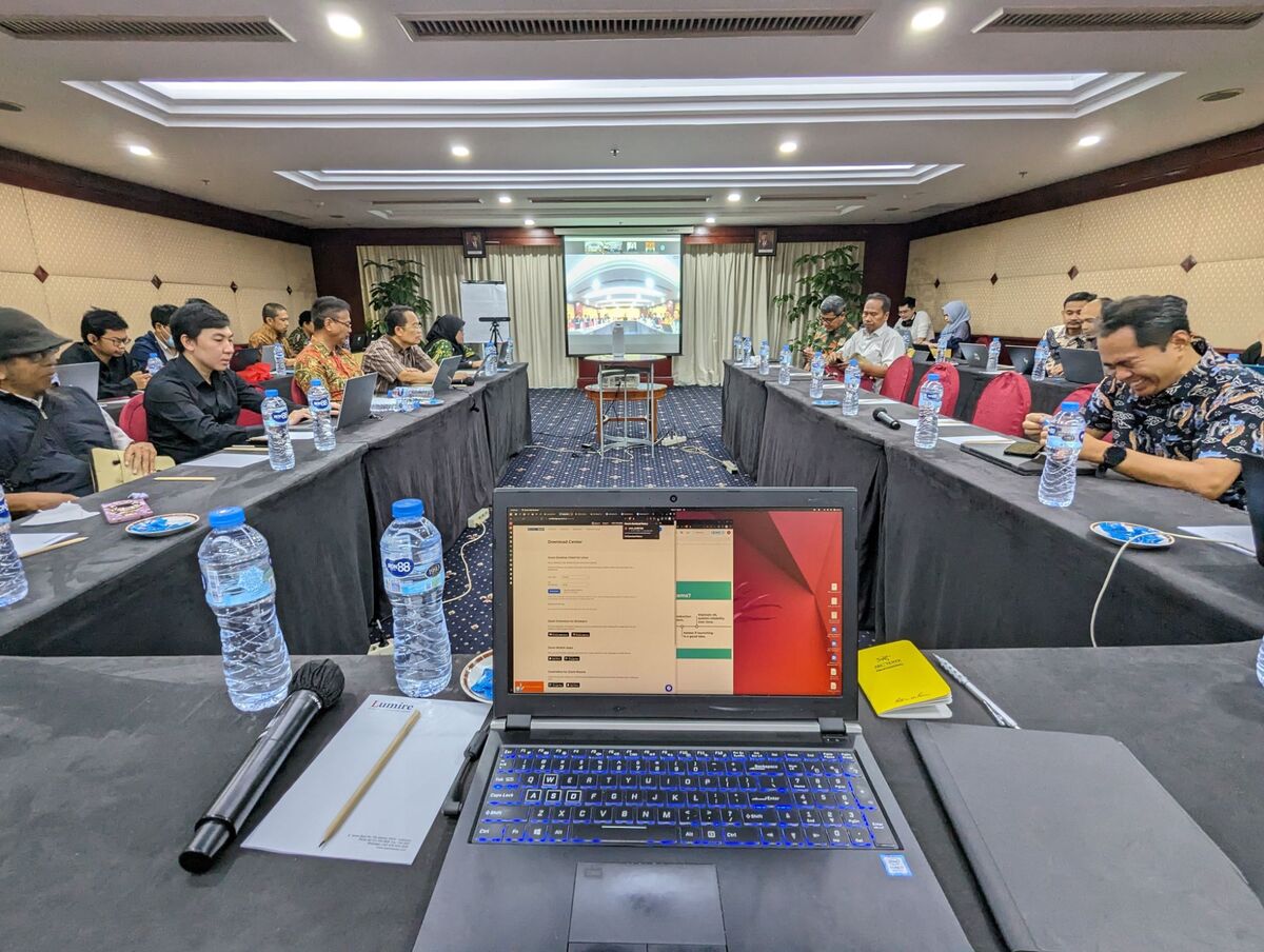 View from the presenter&rsquo;s seat at a workshop, with a laptop in the foreground and participants along both sides of the room.