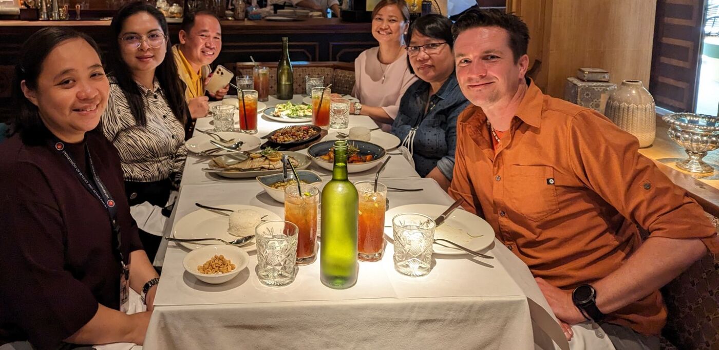 Bartosz Solowiej at a table with members of the Philippine Department of Budget and Management team.